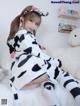 a woman in a cow costume sitting on a bed