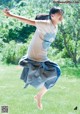 A young girl is jumping in the air in a park.