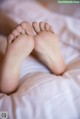 A close up of a person's feet on a bed.