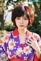 A woman in a purple kimono posing for a picture.