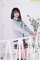 A young woman in a school uniform posing for a picture.