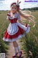 A woman in a red and white dress standing in a field.