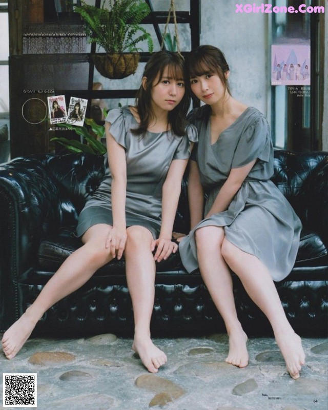 Two young women sitting on a black couch.