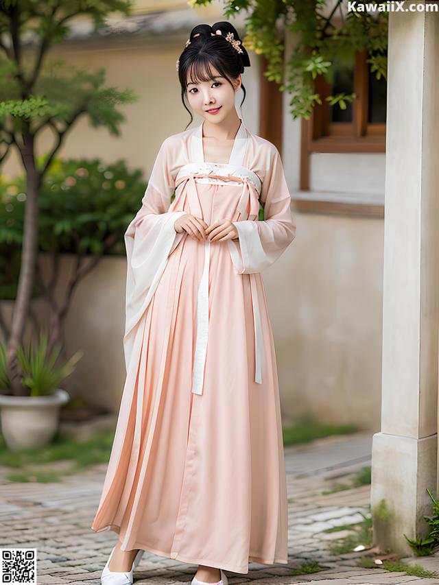 A woman in a pink hanbok is posing for a picture.
