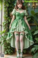 a woman in a green dress and stockings posing for a picture